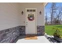 Elegant front door with wreath, stylish sconces, and stone accents at 1784 Treymire Ct, Stone Mountain, GA 30088