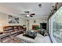 Comfortable living room with a leather sofa, fireplace, built-in shelving, and large windows at 3034 Brookgreen Trl, Lawrenceville, GA 30043