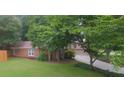 Brick home with two-car garage, lush landscaping, and a well-maintained lawn, offering great curb appeal at 11940 Wexford Club Dr, Roswell, GA 30075