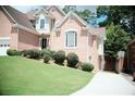 Brick home with brick facade, manicured shrubbery, driveway, and well-maintained lawn at 1255 Home Place Dr, Lawrenceville, GA 30043