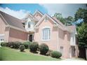 Two-story brick home showcasing manicured shrubbery, brick facade, and neutral trim details at 1255 Home Place Dr, Lawrenceville, GA 30043