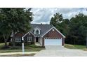 Beautiful brick home with a two-car garage, lush green lawn, and a mailbox at 3066 Gem Creek Rd, Buford, GA 30519