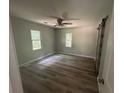 Bedroom featuring hardwood floors, ceiling fan, two windows and sliding barn door at 4610 Wilson James Sw Rd, Atlanta, GA 30331