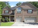Charming two-story brick home featuring a manicured front yard and a two-car garage at 5896 Cliftondale Dr, Atlanta, GA 30349