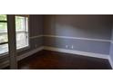 Neutral-toned room featuring hardwood floors, white trim, and natural light from a window at 5896 Cliftondale Dr, Atlanta, GA 30349