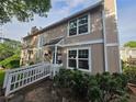 Charming two-story home with large windows, wooden walkway, and lush greenery in a well-kept neighborhood at 1297 Tree Creek Ct, Clarkston, GA 30021