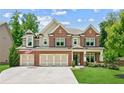 Charming two-story brick home with a three-car garage and well-manicured lawn at 4972 Park Vale Dr, Sugar Hill, GA 30518