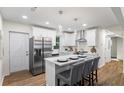Contemporary white kitchen features a center island, stainless appliances, and hardwood floors at 1270 Graymont Sw Dr, Atlanta, GA 30310