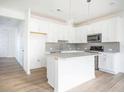 Modern kitchen with white cabinets, gray backsplash, and stainless steel appliances at 1648 Florence Nw Run, Atlanta, GA 30318