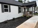 Renovated house boasting a white brick exterior, black shutters, and newly installed black mulch at 1937 Don Juan Ln, Decatur, GA 30032