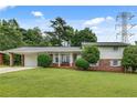 Charming home featuring a well-maintained lawn, a brick facade, and a convenient carport at 5440 Huron Dr, Lake City, GA 30260