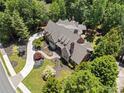 Aerial view of a luxury home featuring lush landscaping, a winding driveway, and a large private lot at 4634 Whitestone Way, Suwanee, GA 30024