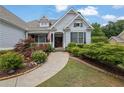 Beautiful home with a well-maintained yard, showcasing mature landscaping and a welcoming walkway to the front entrance at 130 Holly Reserve Pkwy, Canton, GA 30114
