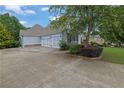 Spacious driveway leading to a three-car garage, surrounded by mature trees and landscaped areas at 130 Holly Reserve Pkwy, Canton, GA 30114