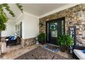 Charming covered front porch featuring stone accents, potted plants, and stylish outdoor seating at 2213 Independence Ln, Buford, GA 30519