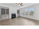 Living room featuring wood floors, fireplace, and built-in cabinets, illuminated by natural light at 377 Danville Ave, Suwanee, GA 30024