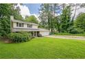 Inviting two-story home with a well-maintained lawn and mature trees providing shade at 5868 Kingswood Nw Ct, Norcross, GA 30093