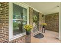 Welcoming entryway with potted plants flanking the front door and a brick facade at 5868 Kingswood Nw Ct, Norcross, GA 30093