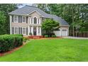 Charming two-story home with manicured lawn, attached two-car garage, and basketball hoop at 121 Clipper Bay Drive, Alpharetta, GA 30005