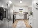 Bright kitchen featuring stainless steel appliances, white cabinets, and light wood flooring at 1250 Timber Walk Dr, Loganville, GA 30052