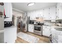 Modern kitchen features stainless steel appliances, white cabinets, and granite countertops at 1250 Timber Walk Dr, Loganville, GA 30052