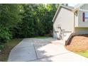 Large driveway leading to a two-car garage, surrounded by mature trees and well-kept lawn at 19 Autumn Ne Pl, White, GA 30184