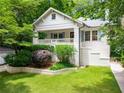 Charming white brick home with a covered front porch and meticulously kept landscaping at 626 Elmwood Ne Dr, Atlanta, GA 30306