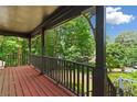 Inviting covered porch with wooden floors, railing, decorative supports and view of the landscaped front yard at 200 Zachary Woods Nw Pt, Marietta, GA 30064