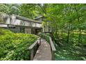 Unique exterior with a wooden walkway surrounded by lush greenery and mature trees at 285 Glen Lake Dr, Atlanta, GA 30327