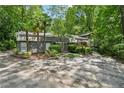 Striking front exterior featuring stone accents, tropical palms, and lush landscaping, creating curb appeal at 285 Glen Lake Dr, Atlanta, GA 30327