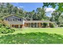Charming two-story home with a well-manicured lawn and mature trees at 4562 Lucerne Valley Sw Rd, Lilburn, GA 30047