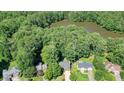 Aerial view of property showing home's location near a serene lake and surrounded by lush trees at 109 Lake Latimer Ne Cv, Kennesaw, GA 30144