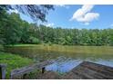 Scenic view of the lake, enhanced by a charming dock and surrounded by beautiful, lush trees at 109 Lake Latimer Ne Cv, Kennesaw, GA 30144