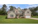 Beautiful two-story home with a manicured lawn, showcasing its appealing brick and siding facade at 2 Whites Pond Rd, Moreland, GA 30259