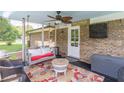 Relaxing screened porch with a swing, ceiling fan, and comfortable seating at 3152 H D Atha Rd, Covington, GA 30014