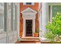 Classic brick townhome entrance with black door, brick steps, white trim, and charming potted plants at 872 Briarcliff Ne Rd # B2, Atlanta, GA 30306