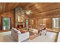 Cozy living room with a stone fireplace, wood paneled walls and ceiling, and comfortable seating at 3852 Vinyard Ne Ct, Marietta, GA 30062