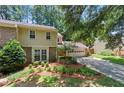 Attractive two-story home with neutral siding, brick accents, mature landscaping, and a two-car garage at 4477 Village Dr, Atlanta, GA 30338