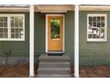 Close-up of a yellow front door with white trim, adding a pop of color to the house at 720 Maynard Se Ter, Atlanta, GA 30316