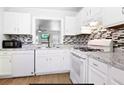 Modern kitchen with white cabinetry, tile backsplash, and updated appliances at 306 Autumn Leaf Way, Norcross, GA 30093