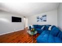 Cozy living room with modern decor, a large blue sectional, and dark wood flooring at 1472 High Meadow Dr, Stone Mountain, GA 30083