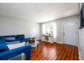 Cozy living room with a modern blue sofa, hardwood floors, and a bright window at 1472 High Meadow Dr, Stone Mountain, GA 30083