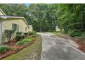 A long driveway leads to a charming home surrounded by lush greenery and tall trees at 2110 Waterloo Cir, Lawrenceville, GA 30043