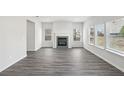 Bright living room featuring gray fireplace, gray vinyl flooring and large windows at 386 Tallulah Ln, Grayson, GA 30017