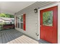 Inviting covered front porch with a swing, red door and a view to a landscaped yard at 1902 Memorial Se Dr, Atlanta, GA 30317