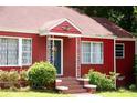 Close-up view of the red brick home's entrance, featuring a decorative front door and well-kept landscaping at 3020 Washington Rd, East Point, GA 30344
