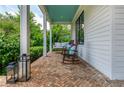 Relaxing front porch with brick flooring, porch swing, rocking chairs, and a blue ceiling at 174 Pearl Se St, Atlanta, GA 30316