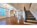 Spacious living room with hardwood floors, a fireplace, built-in shelving, and ample natural light at 6515 Bentley Ridge Dr, Cumming, GA 30040