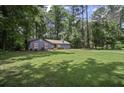 Charming single-story home with blue siding, red shutters, and a lush green lawn at 539 Karen Dr, Alpharetta, GA 30009