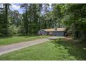 View of the front of the home with a long driveway and mature trees at 539 Karen Dr, Alpharetta, GA 30009